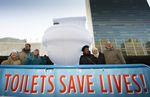 Eine Gruppe von VN-Mitarbeitenden hält ein Transparent mit den Worten "Toilets save lives".