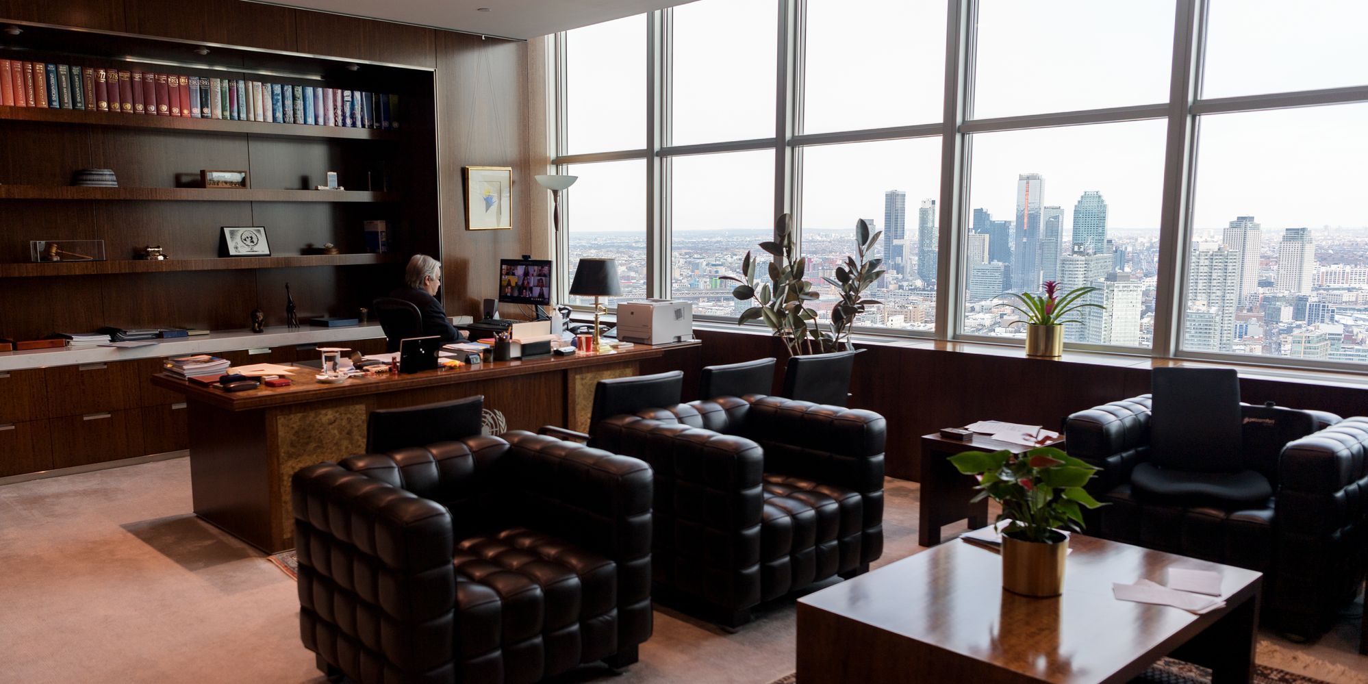Büro des UN-Generalsekretärs. UN Photo: Manuel Elías Blick ins Büro mit Ledersesseln, Bücherregal und Fensterfront mit Sicht auf die Skyline von Queens.