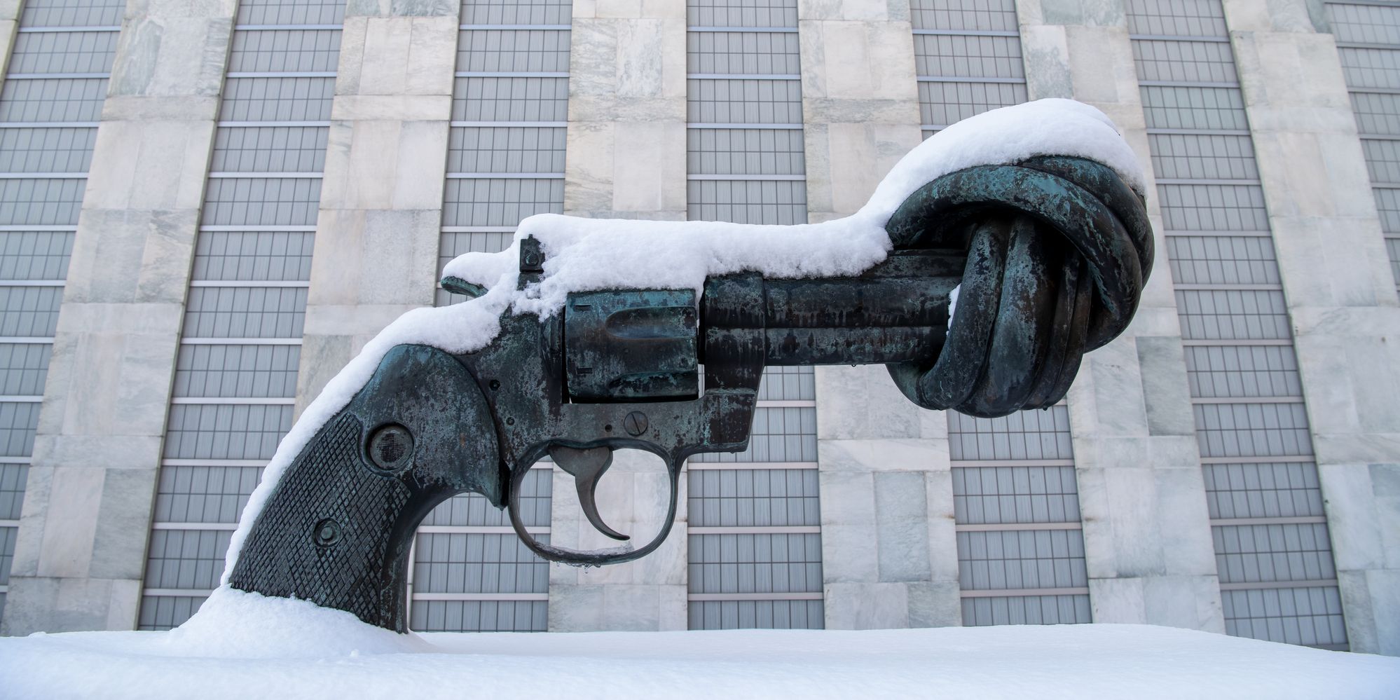 Die Skulptur 'Knotted Gun', eine Pistole deren Lauf verdreht ist, vor dem UN-Sekretariatsgebäude ist von Schnee bedeckt.